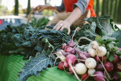 Midsection of woman buying vegetables at market