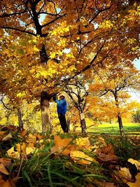 Full length of person on yellow tree during autumn