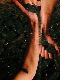 High angle view of hands on wet land