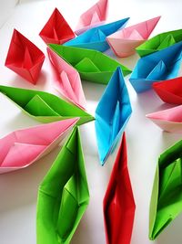 Multi colored paper boats on table