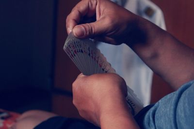 Midsection of man holding cards