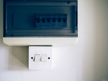 Close-up of electric lamp on wall at home