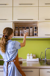 Rear view of woman standing at home