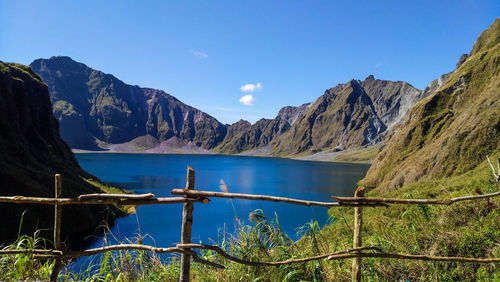 Scenic view of lake and mountains against blue sky