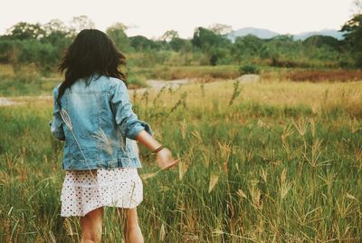 Rear view of woman standing on field