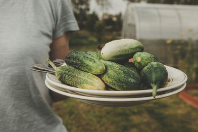 Midsection of man holding strawberry while standing outdoors