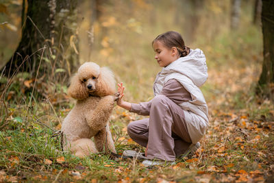 Portrait of young man with dog on field