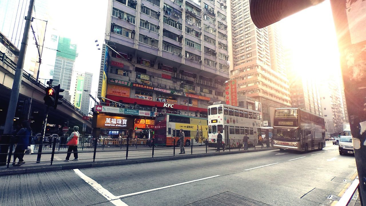 architecture, building exterior, built structure, transportation, car, city, street, land vehicle, city street, road, mode of transport, city life, road marking, incidental people, street light, the way forward, building, traffic, sunlight, zebra crossing