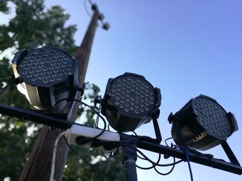 Low angle view of spotlights against clear blue sky