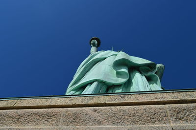 Low angle view of statue against blue sky