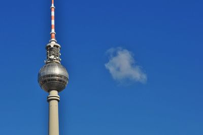 Low angle view of communications tower against blue sky