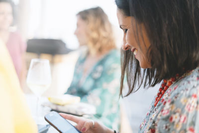 Midsection of woman holding drink at table