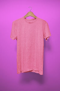 Close-up of pink bell hanging against purple background