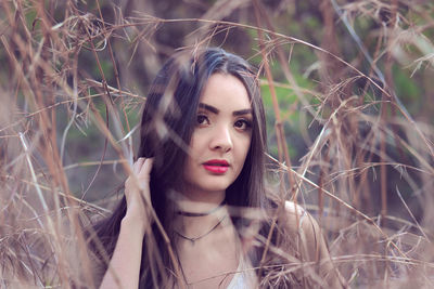 Portrait of young woman amidst grass