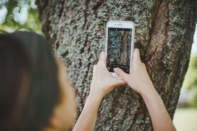 Midsection of person using mobile phone in park