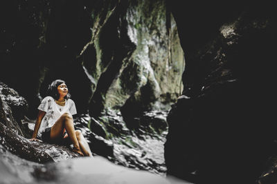 Woman sitting on rock canyon in bali