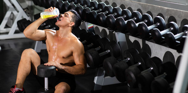 Shirtless man exercising in gym