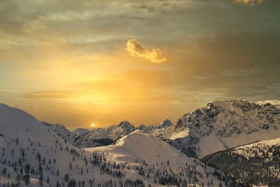 Scenic view of snow covered mountains against sky during sunset