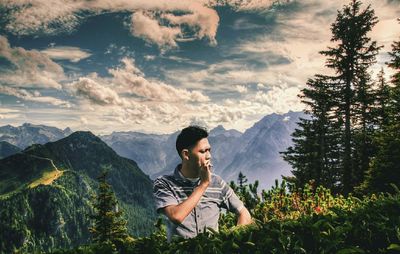 Beautiful young woman on land against sky