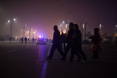 People in illuminated amusement park