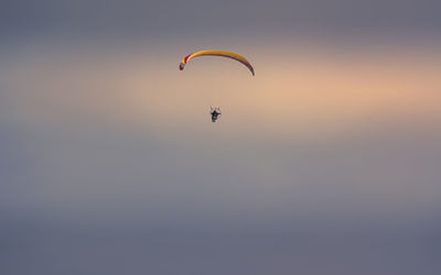 Low angle view of person paragliding against sky