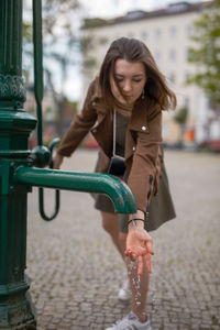 Woman with hand on water pouring from faucet