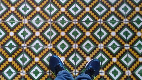 Low section of people standing on tiled floor