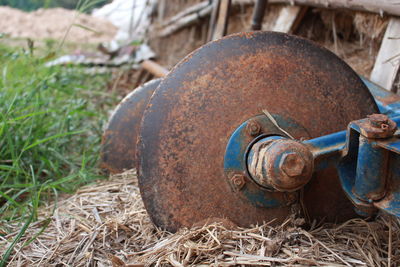 Close-up of rusty wheel on straws