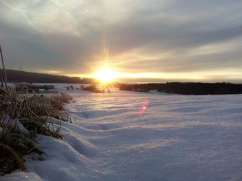 Scenic view of snow covered landscape at sunset