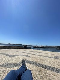 Low section of man against blue sky