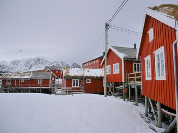 Houses on frozen landscape against sky