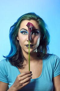 Portrait of a beautiful young woman against blue background