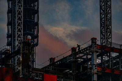 Low angle view of crane against sky during sunset