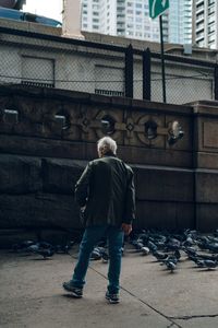 Full length rear view of man standing in city