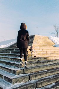 Full length of woman standing on steps
