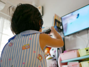 Rear view of man using mobile phone