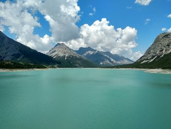 Scenic view of lake by mountains against sky