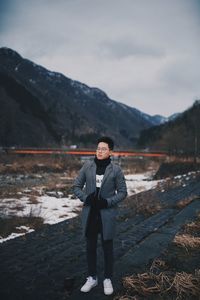 Portrait of man standing on mountain against sky