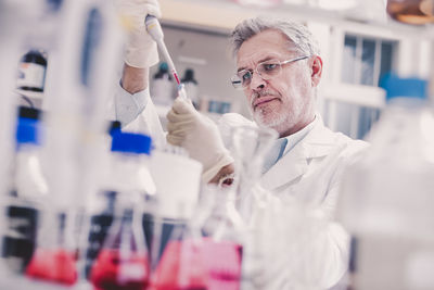 Female scientist examining chemical in laboratory