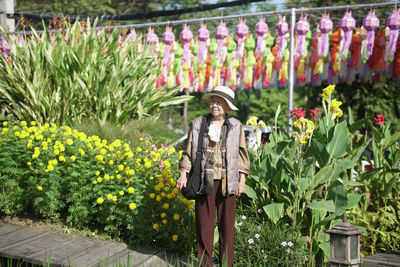 Rear view of woman standing against plants