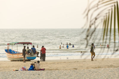 People at beach against sky