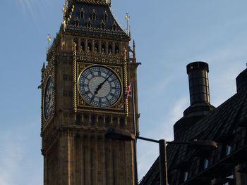 Low angle view of clock tower against cloudy sky