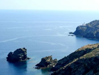High angle view of rock formations by sea against sky