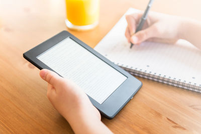 Midsection of man using mobile phone on table