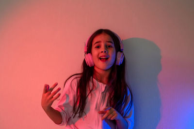 A dancing little girl in pink headphones