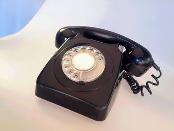 High angle view of black rotary phone on white table