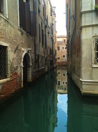 Canal amidst buildings against sky