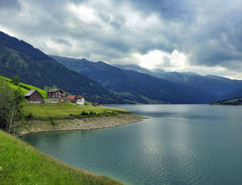 Scenic view of lake by mountains against sky