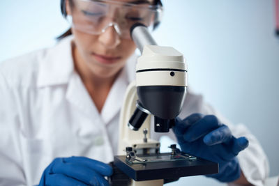 Scientist looking through microscope at lab