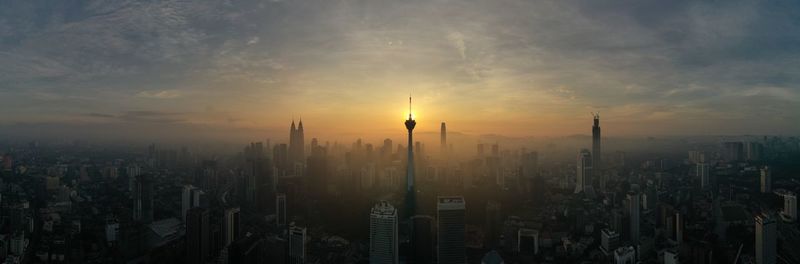 Sun shining over buildings in city